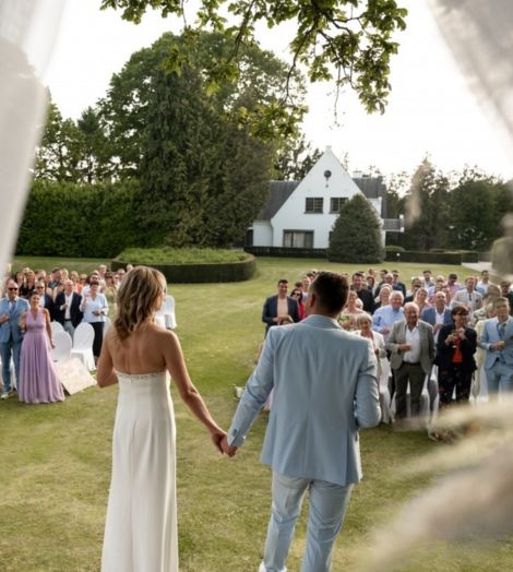 Domein Martinus trouwend koppel staat voor genodigden in de tuin