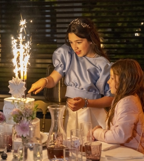 Kind snijdt taart aan communie groeifeest