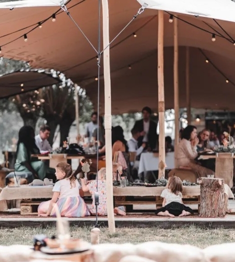 Kinderen aan kindertafel locatie met tent