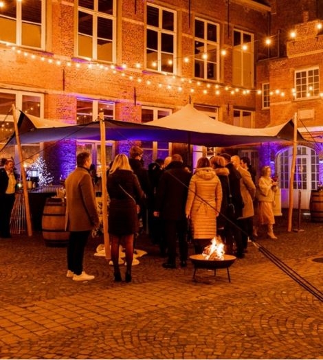 Tent buiten tussen gebouwen met vuurkorf 4events