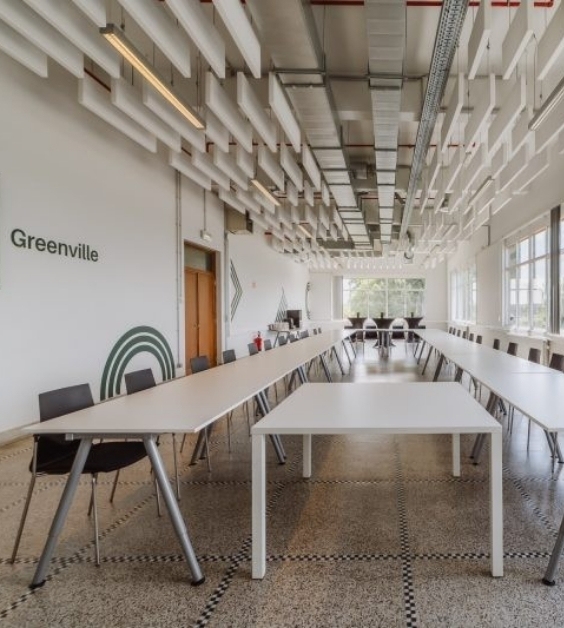 Vergaderruimte met veel stoelen aan lange tafel